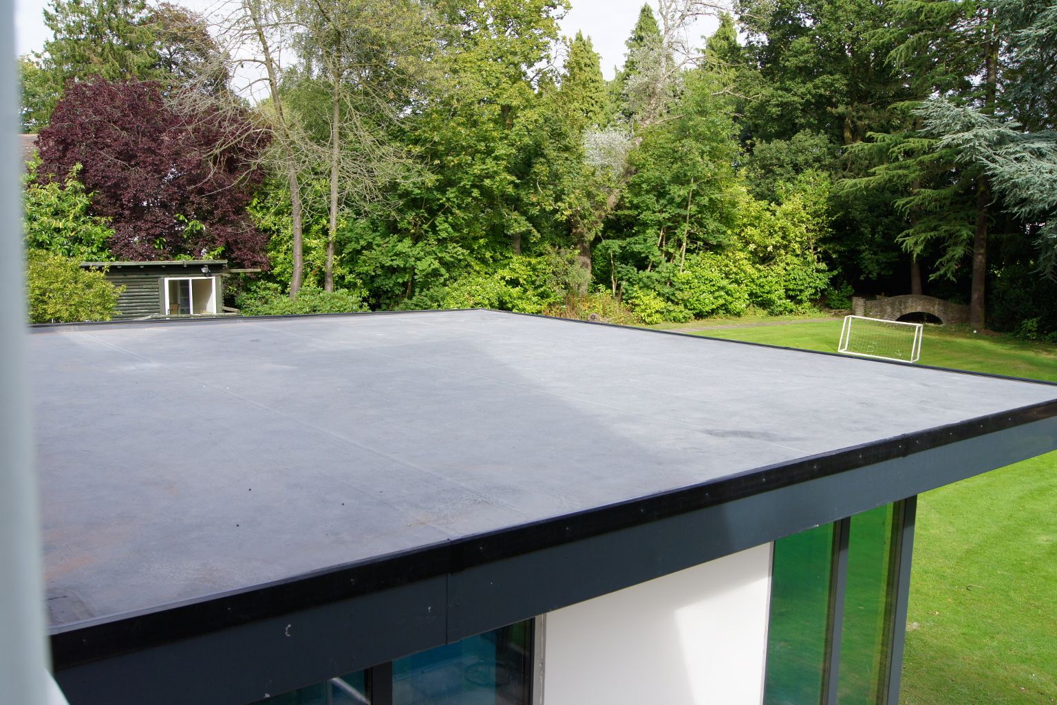 Completed dark sheet membrane on the low-slope roof of a modern home