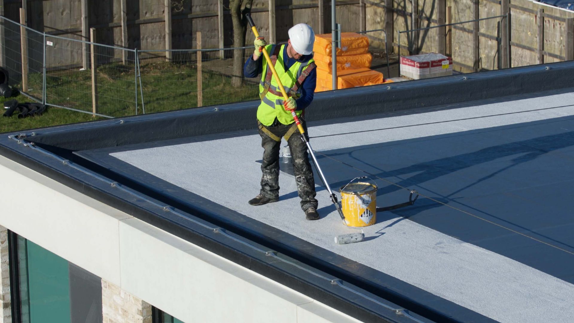 Waterproofing contractor applying a liquid membrane to a flat roof